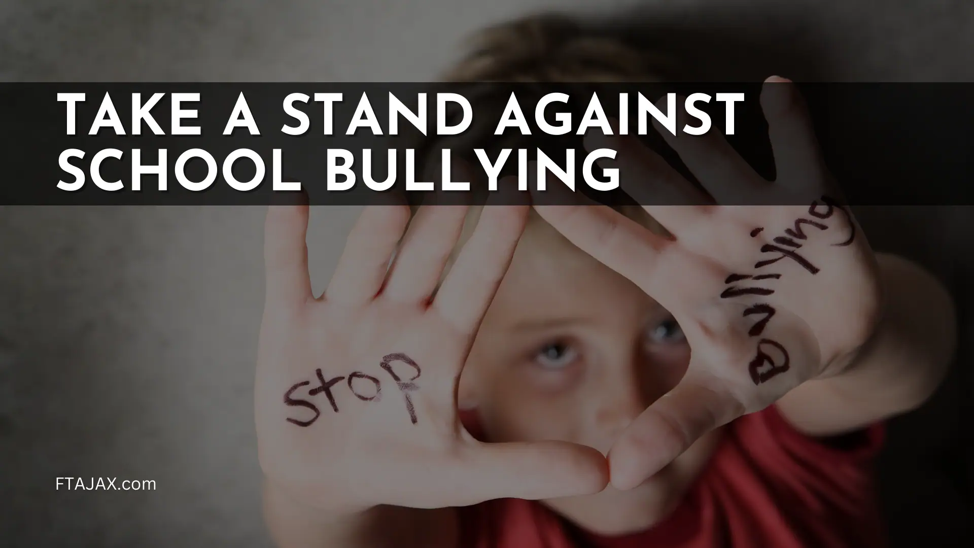 A child holds up hands with the words "stop" and "bullying" written on them, promoting a stand against school bullying